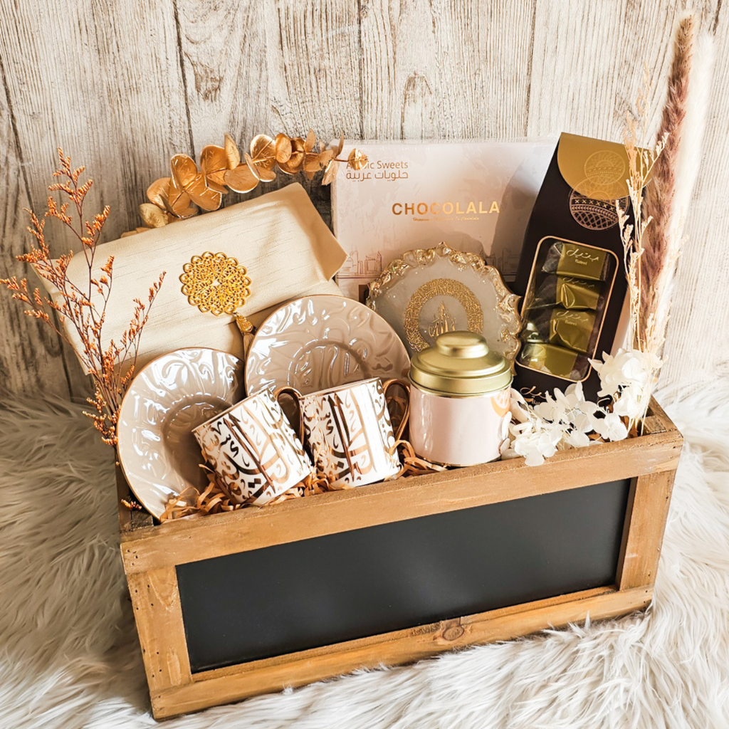 Welcoming Ramadan gift box featuring assorted Arabic baklava, kahwa cup and saucer, Bateel dates, prayer mat, tasbih, and decorative piece.